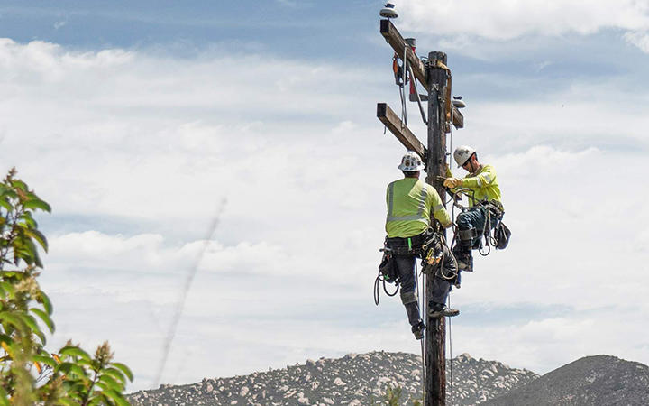 image of lineworkers on an electric pole